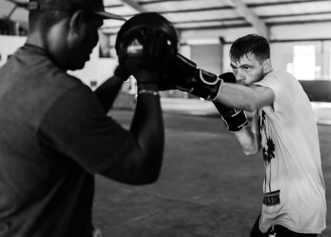 two boxers fighting in a match wearing protective head gear